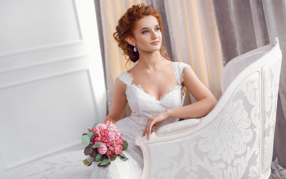 Девушка в свадебном платье сидит