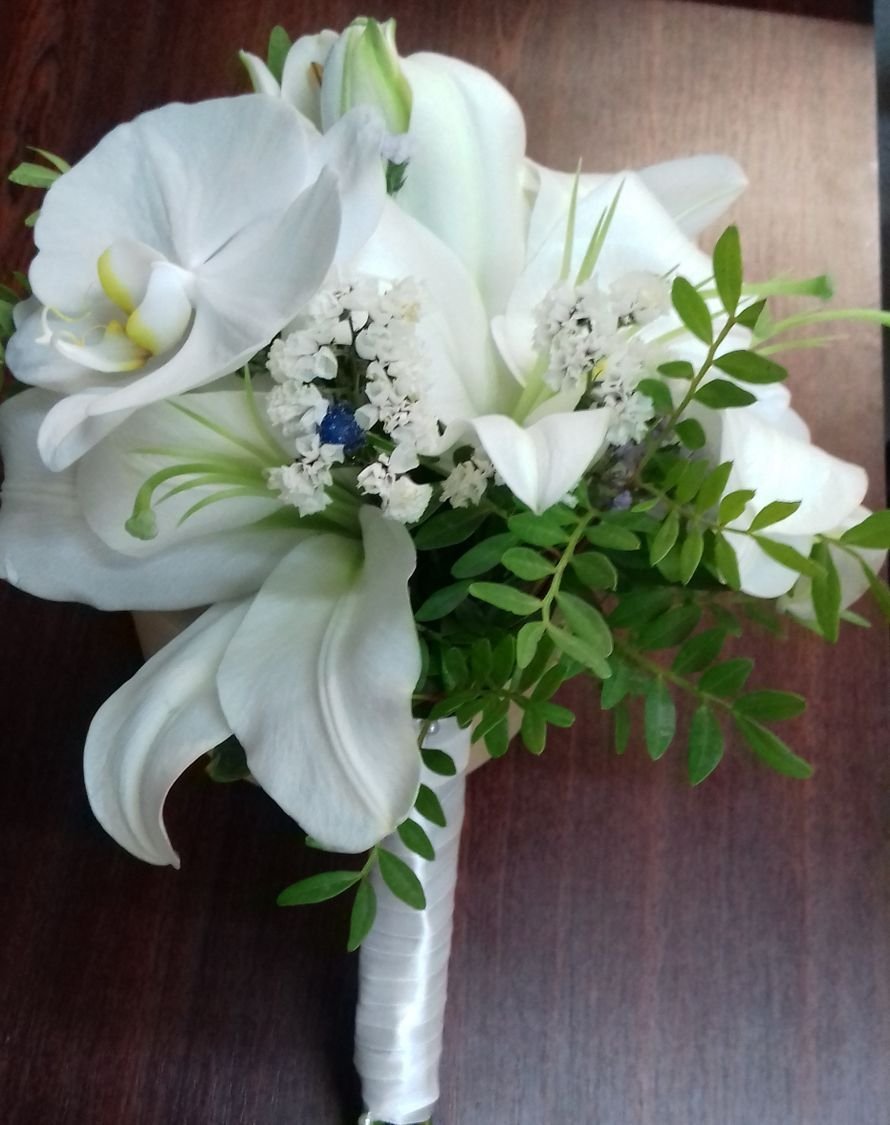 Невеста держит свадебный букет из лилии