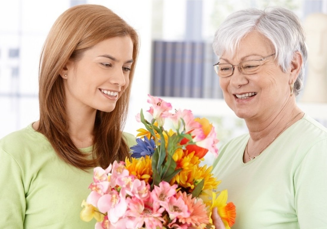 Есть праздник свекрови. Подарок бабушке. Ребенок дарит цветы маме. Букет для мамы. Пожилая женщина с букетом цветов.