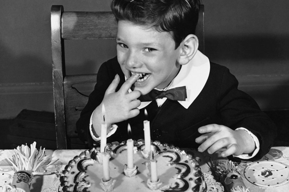 Мальчик задувает свечи на торте