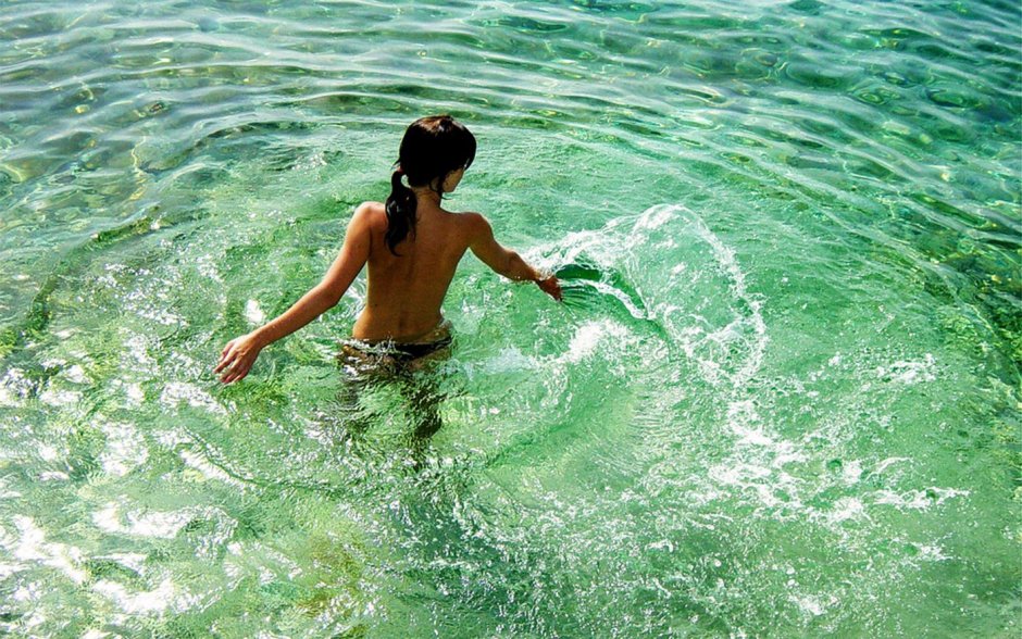 Девушка купается в море