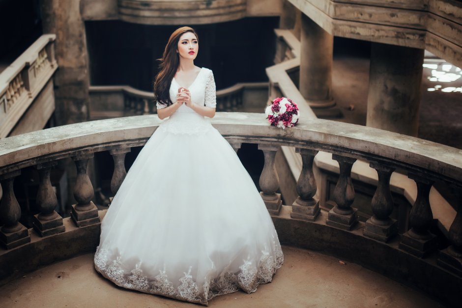 Девушка в свадебном платье сидит