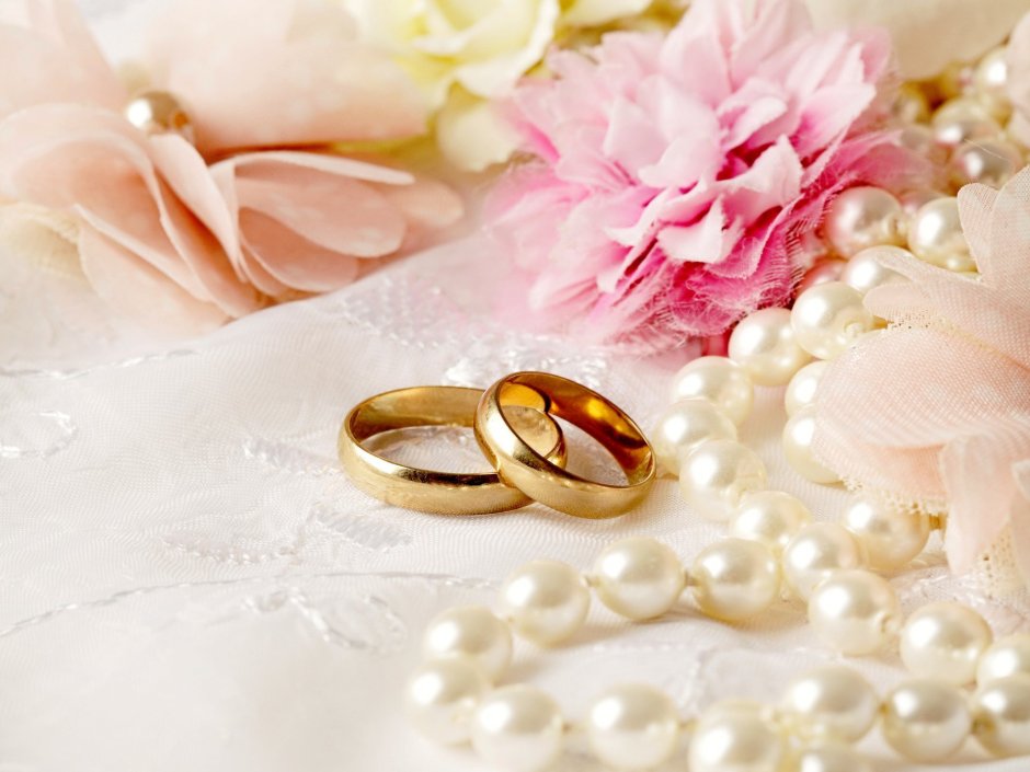 Обручальные кольца на фоне цветов