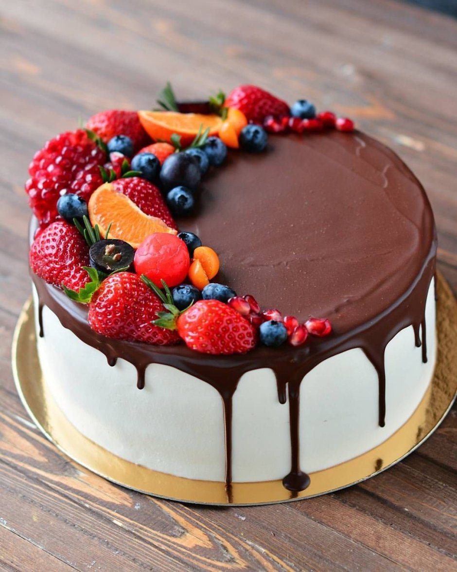 Торт украшенный клубникой и голубикой и шоколадом
