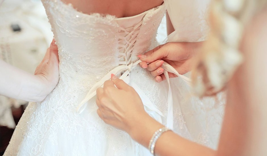 Девушка в салоне свадебном платье меряет