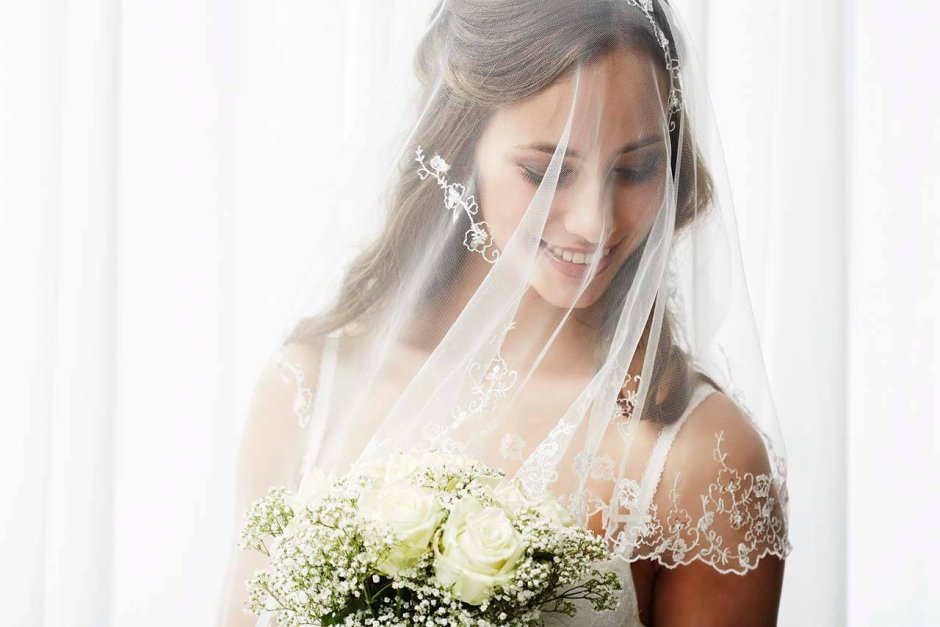 Девушка в свадебном платье боком