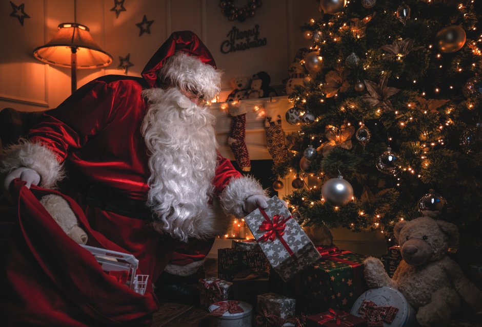 Санта кладет подарки под елку