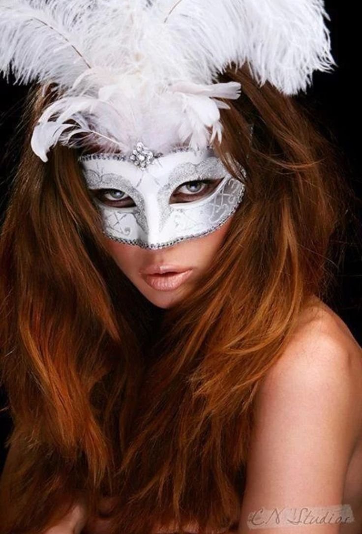 Девушка в маске с перьями