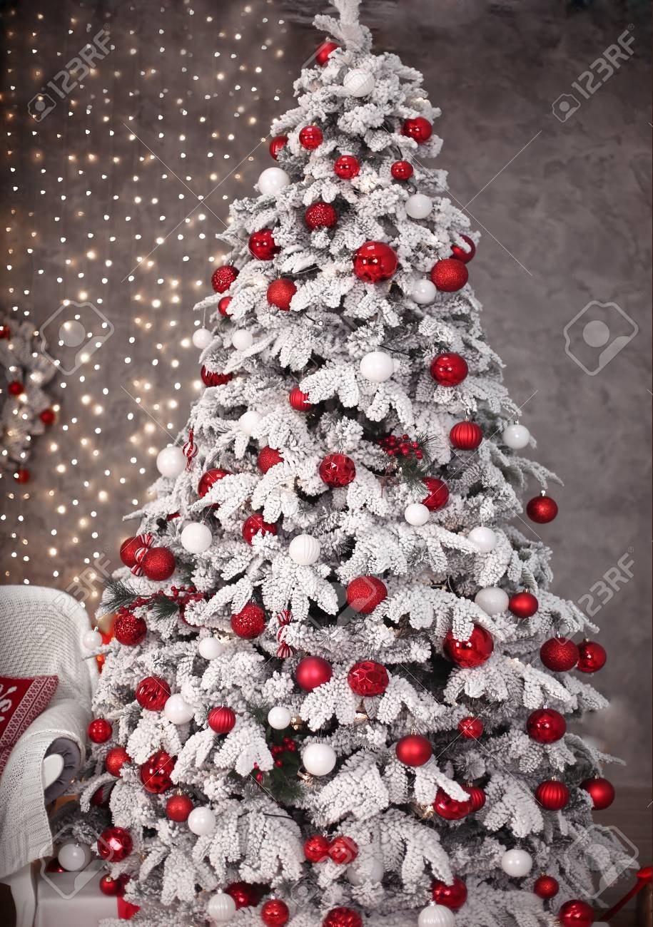 Заснеженная елка с красными шарами