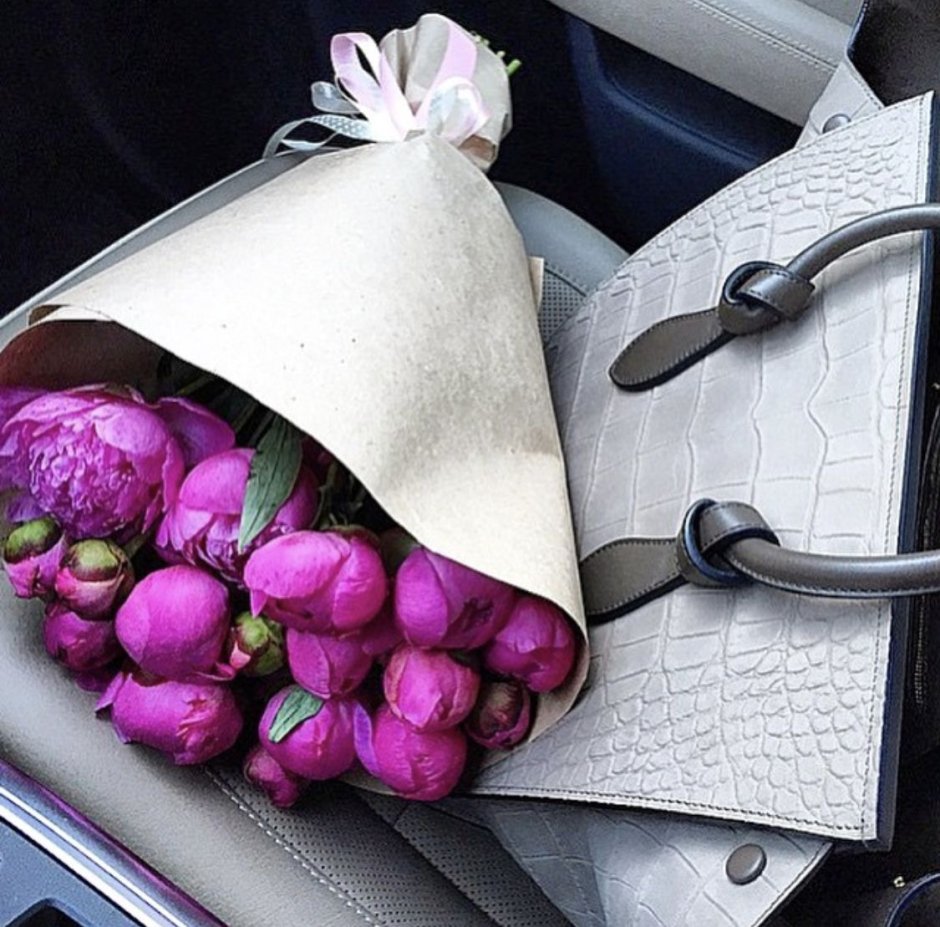 На машине букет цветов и сумочка