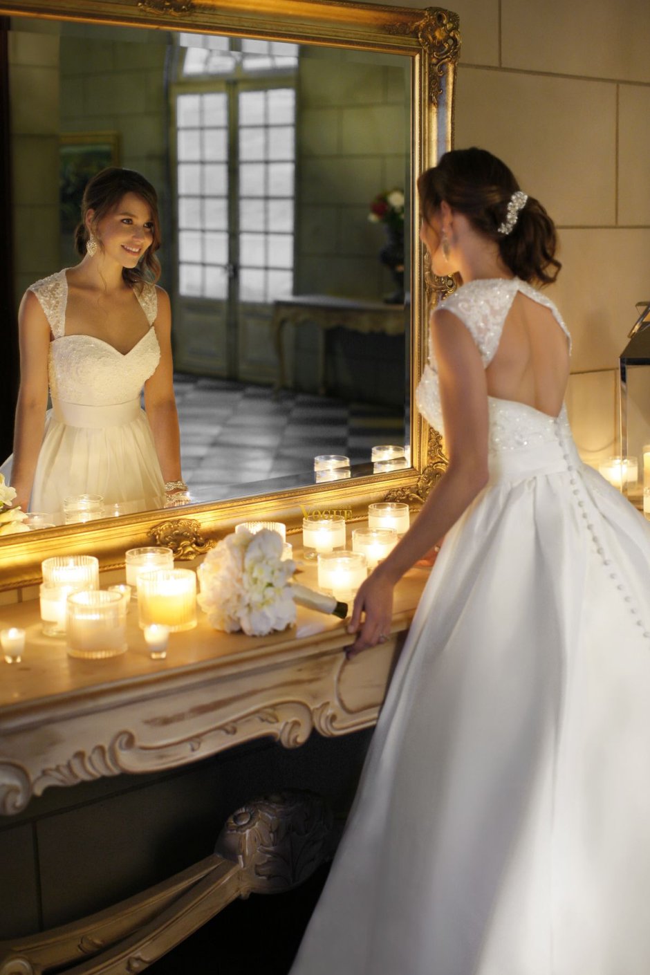 Девушка в свадебном платье перед зеркалом