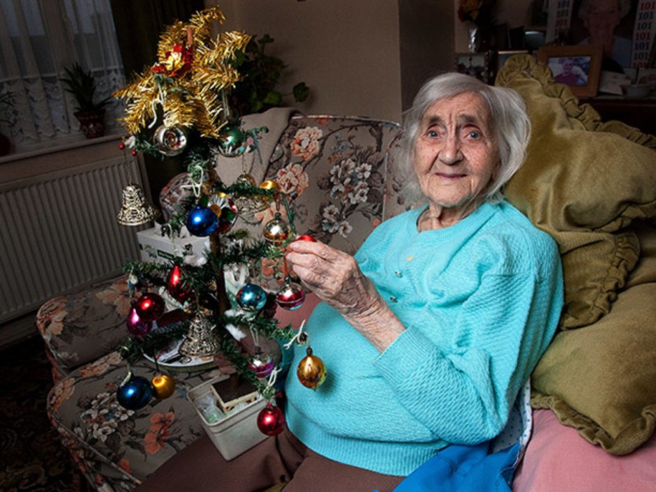 Пожилая женщина у новогодней ёлки